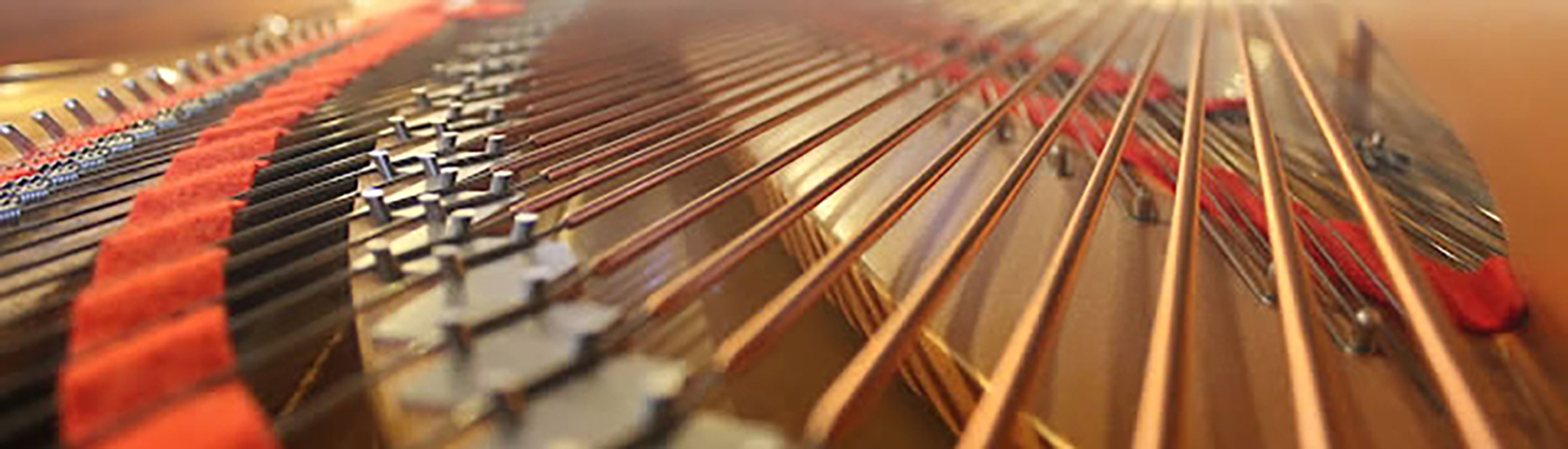 Close-up of piano strings and hammers inside a grand piano